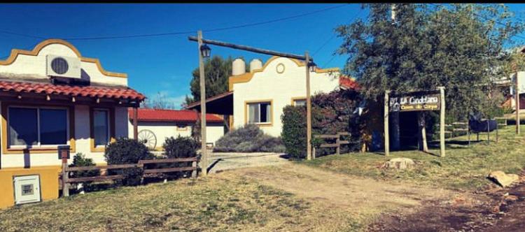 un edificio con una señal delante de él en La Candelaria - Casas de Campo - en Sierra de la Ventana