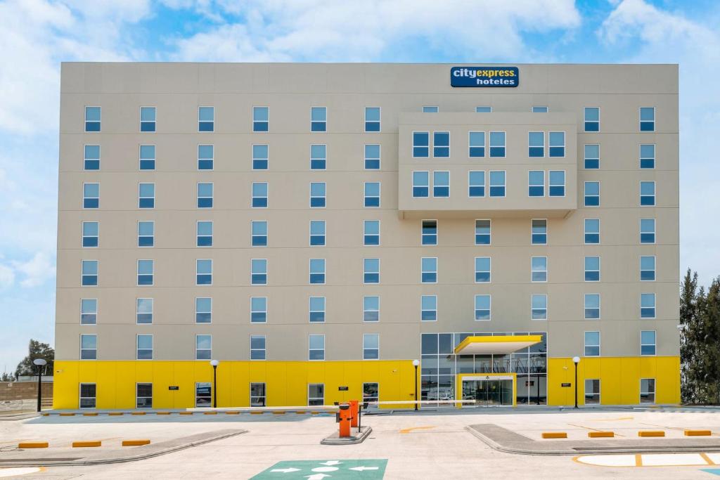 a large building with a blue sign on top of it at City Express by Marriott Lagos de Moreno in Lagos de Moreno