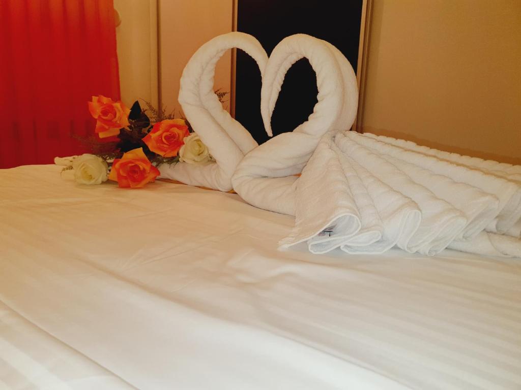 uma cama com dois cisnes feitos de toalhas em Family Apartment em Kumanovo