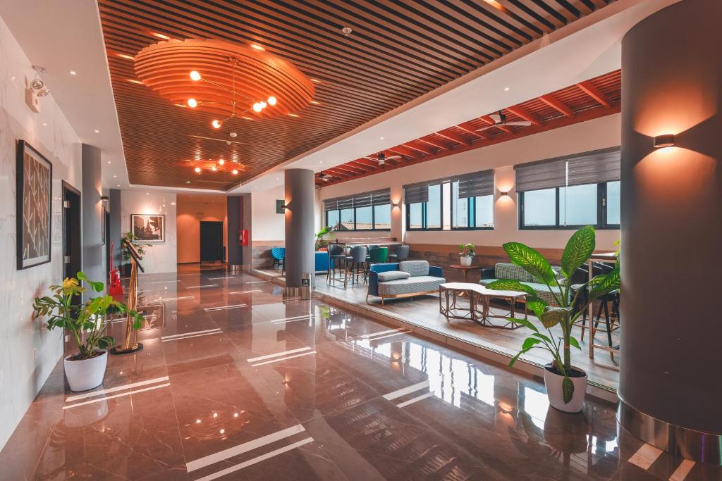 un hall avec des plantes en pot dans un bâtiment dans l'établissement Lyz Business Hotel Piura, à Piura