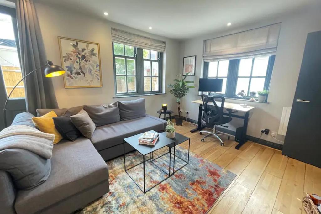 a living room with a couch and a desk at Contemporary 1BD Flat wGarden - Whitechapel in London