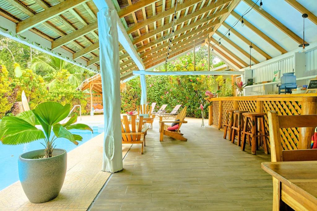 un patio con mesa, sillas y piscina en La Rana De Cahuita, en Cahuita