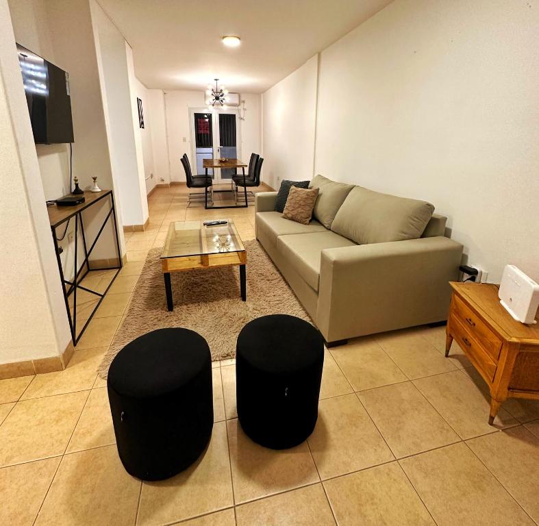 a living room with a couch and two stools at Paramont Rosario 2 in Rosario de la Frontera