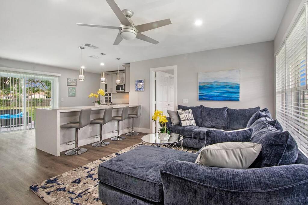 a living room with a blue couch and a kitchen at Modern getaway near the beach with room for a boat in West Palm Beach