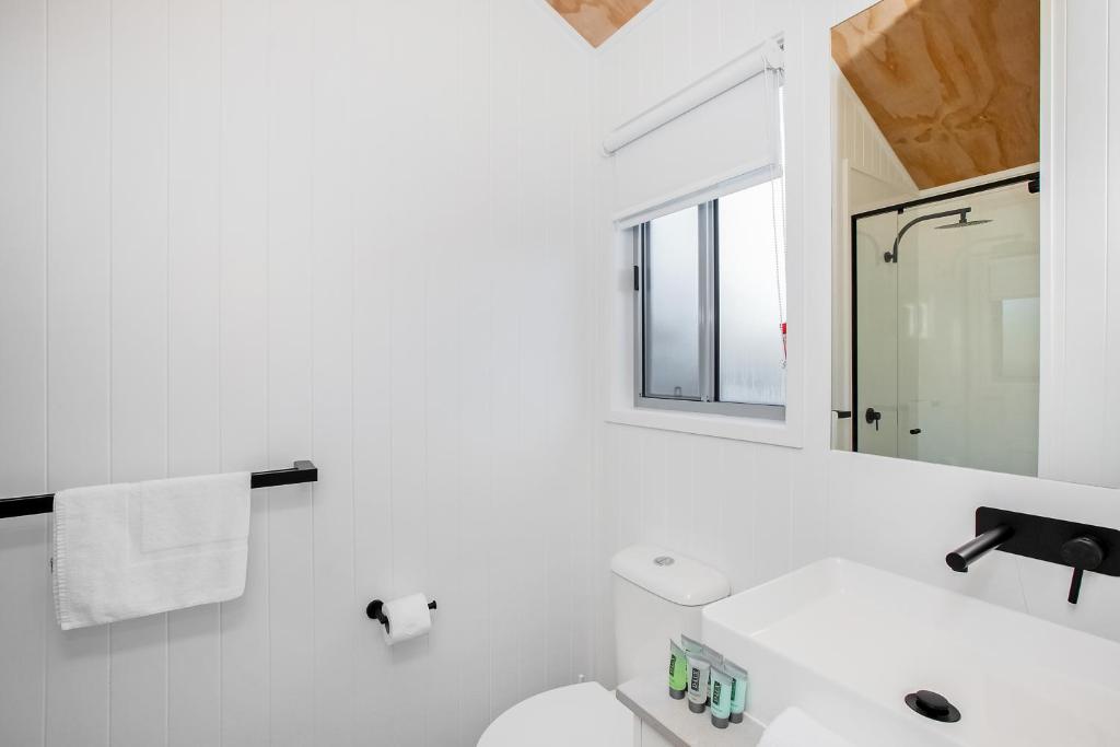 ein weißes Badezimmer mit einem Waschbecken und einem Spiegel in der Unterkunft Reflections Scotts Head - Holiday Park in Scotts Head