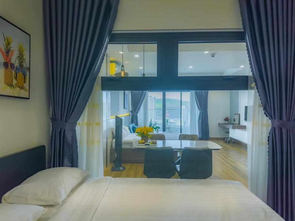a bedroom with a bed and a table with chairs at Grand Hyams Hotel - TMS Tầng 21 View Biển Quy Nhơn - 2PN in Quy Nhon