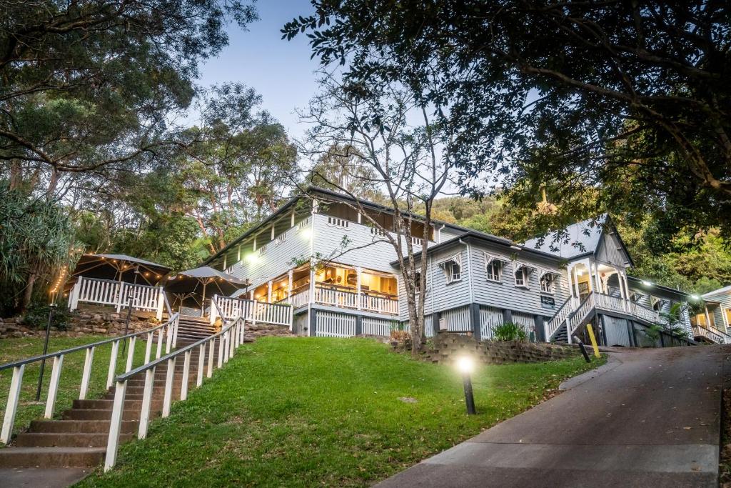 a large white house with a porch at Halse Lodge Noosa Heads in Noosa Heads