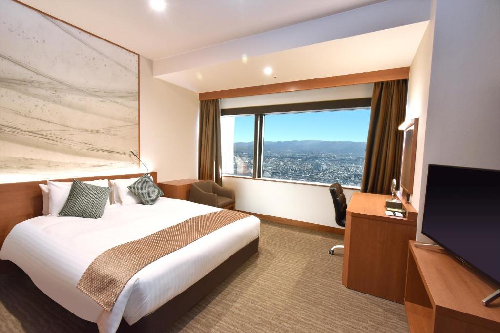 a hotel room with a bed and a large window at Odysis Suites Osaka Airport Hotel in Izumi-Sano