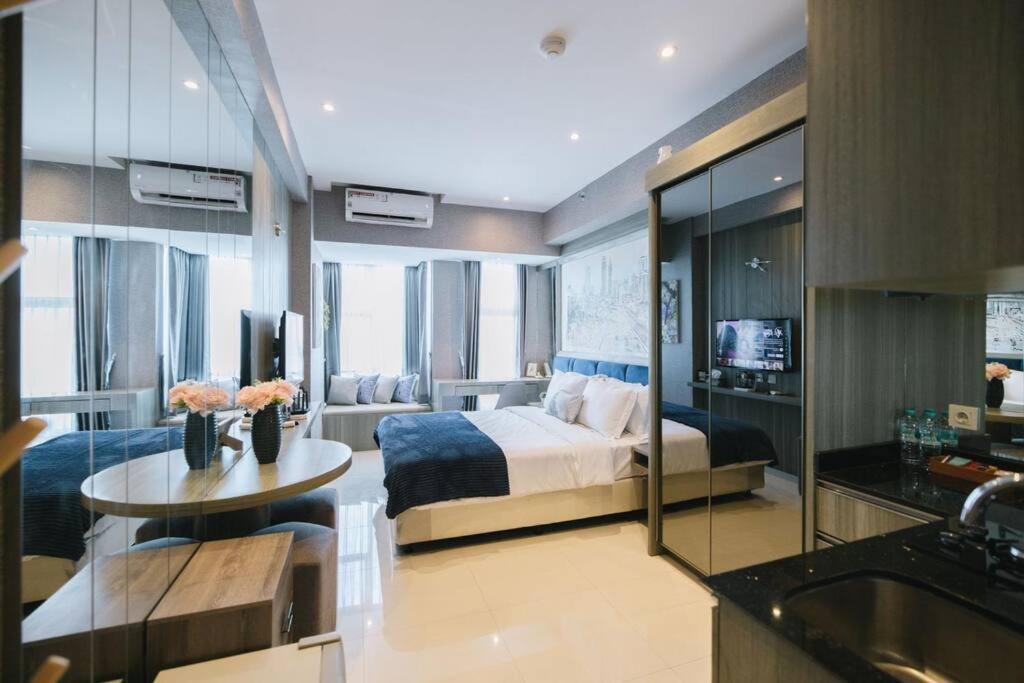 a bedroom with a bed and a table in a room at Lavy at Anderson Pakuwon Mall in Surabaya