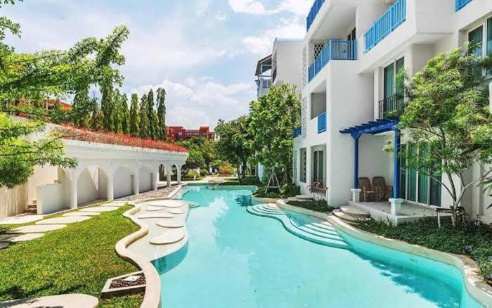 a swimming pool in front of a building at Chelona Hua Hin in Khao Tao