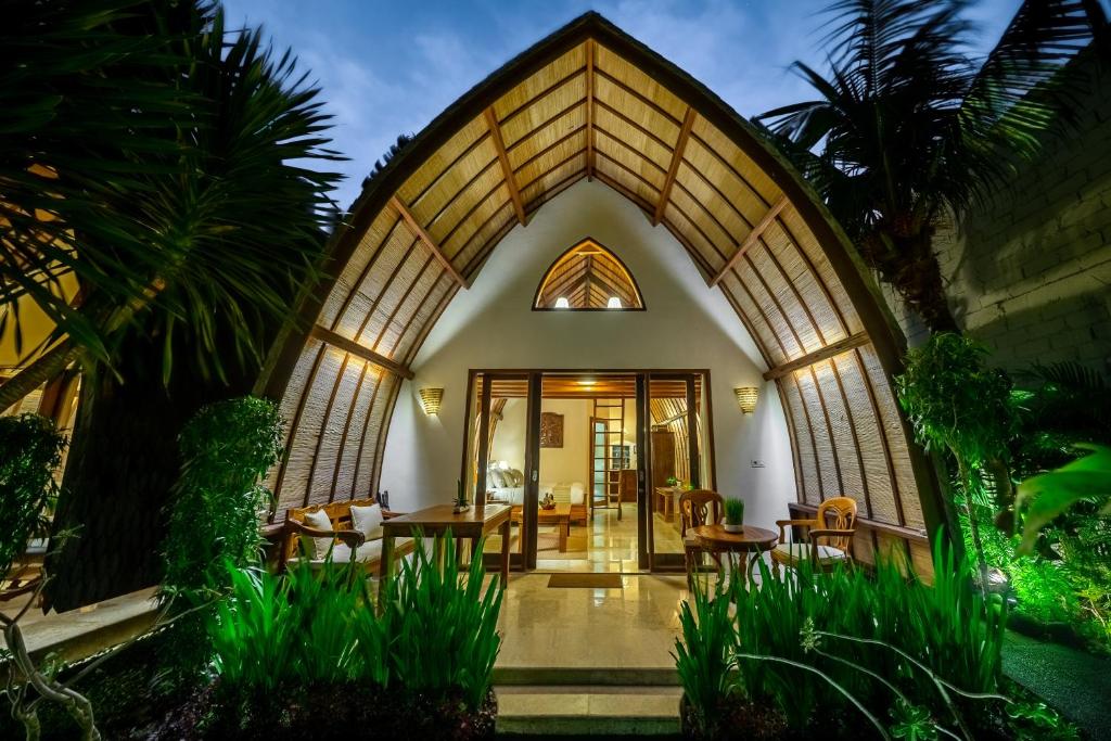 an entrance to a home with a large arched doorway at Klumpu Bali Resort in Sanur