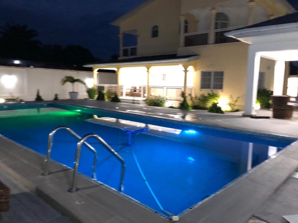 a swimming pool in front of a house at night at villa piscine timbamba in Pointe-Noire
