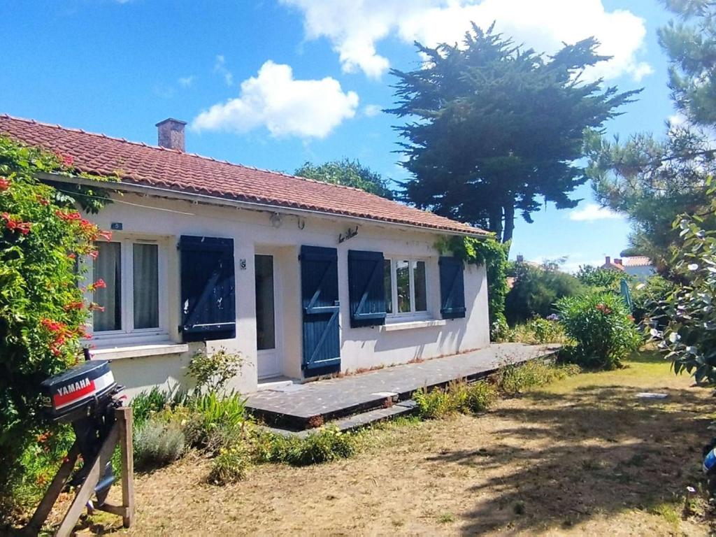 Cette petite maison blanche dispose de fenêtres bleues et d'une cour. dans l'établissement Maison cosy 6 pers, plage à 160m, jardin clos, plancha, ménage inclus - FR-1-224B-204, à Noirmoutier-en-l'lle