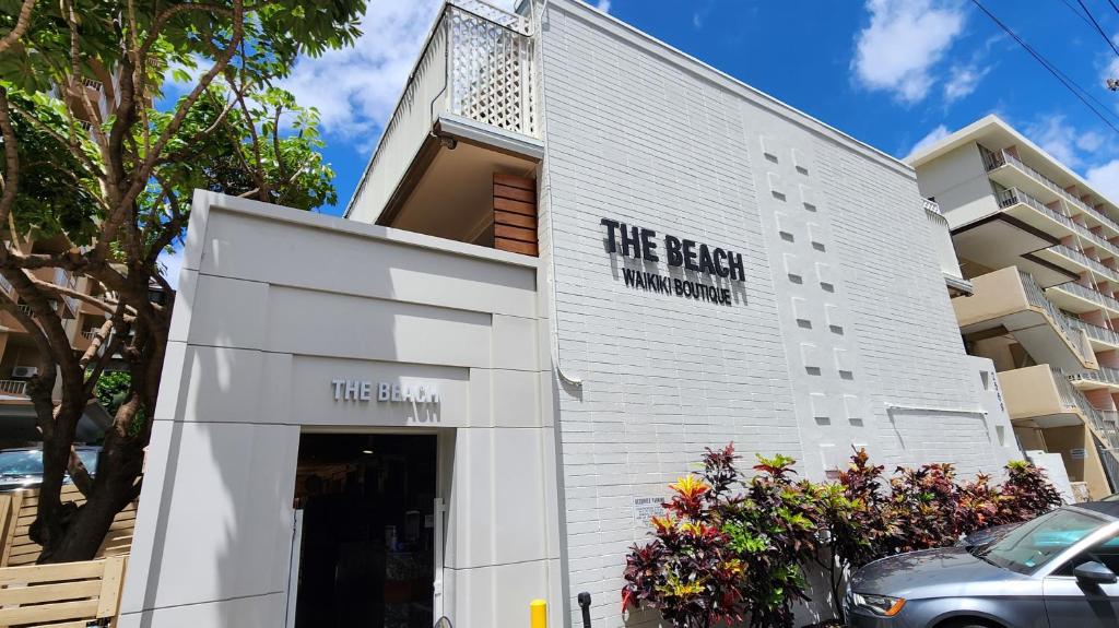 um edifício branco com um sinal que lê o depósito de cabelo em The Beach Waikiki Boutique Hostel em Honolulu