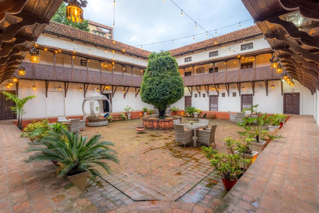 a courtyard of an old building with a lot of plants at Hukum Darbar Restaurant & Hotel in Kathmandu