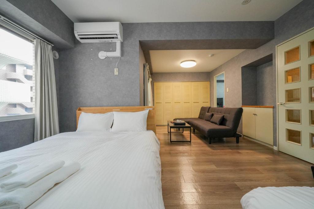 Habitación de hotel con cama y silla en Residence Hotel KABUTO en Sapporo