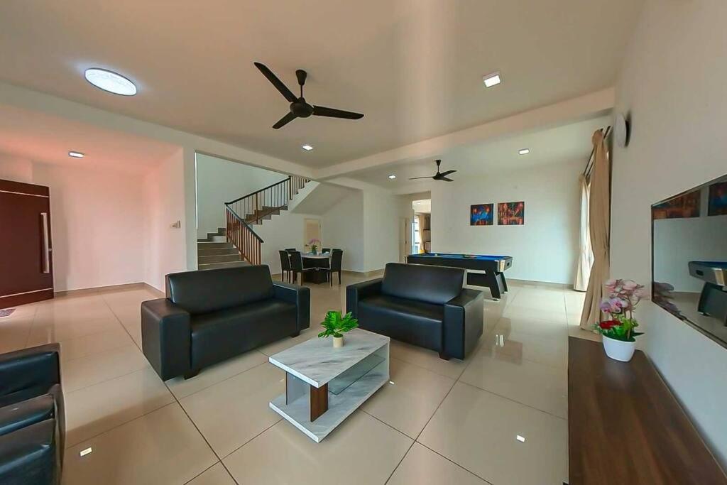 a living room with two couches and a ceiling fan at Desaru Spacious 6 Rooms Bungalow 22paxes KTV-Billard-BBQ-Netflix in Kota Tinggi