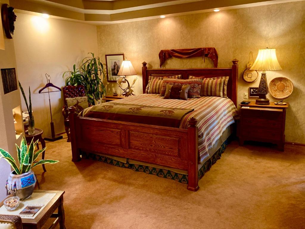 1 dormitorio con 1 cama grande y 2 mesas en Yellowstone Cattle Baron EnSuite, Private Entrance & Parking - Prairie Rose B&B en Cheyenne
