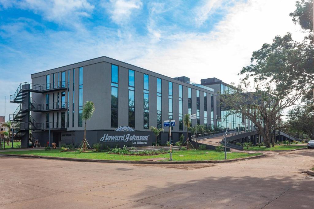 un grand bâtiment avec un panneau sur son côté dans l'établissement Howard Johnson Plaza La Ribera, à Resistencia