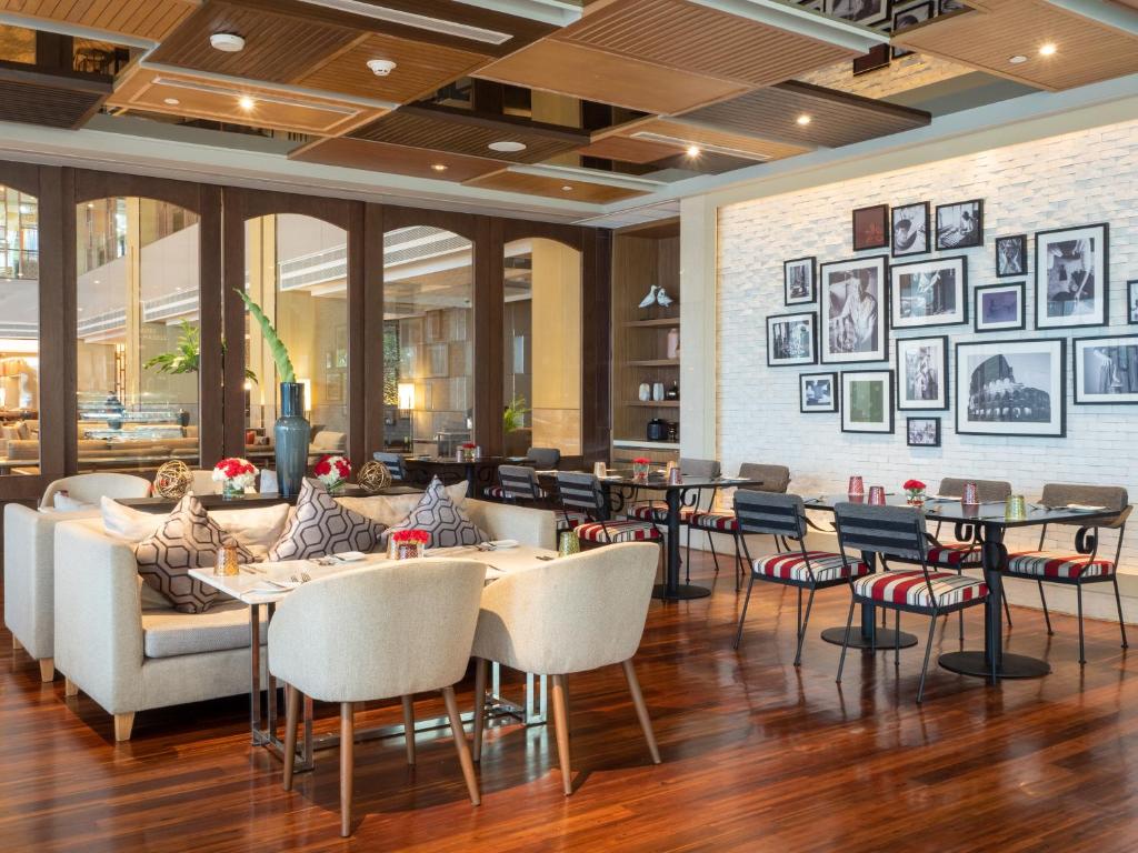 a restaurant with tables and chairs in a lobby at Amari Bangkok in Bangkok