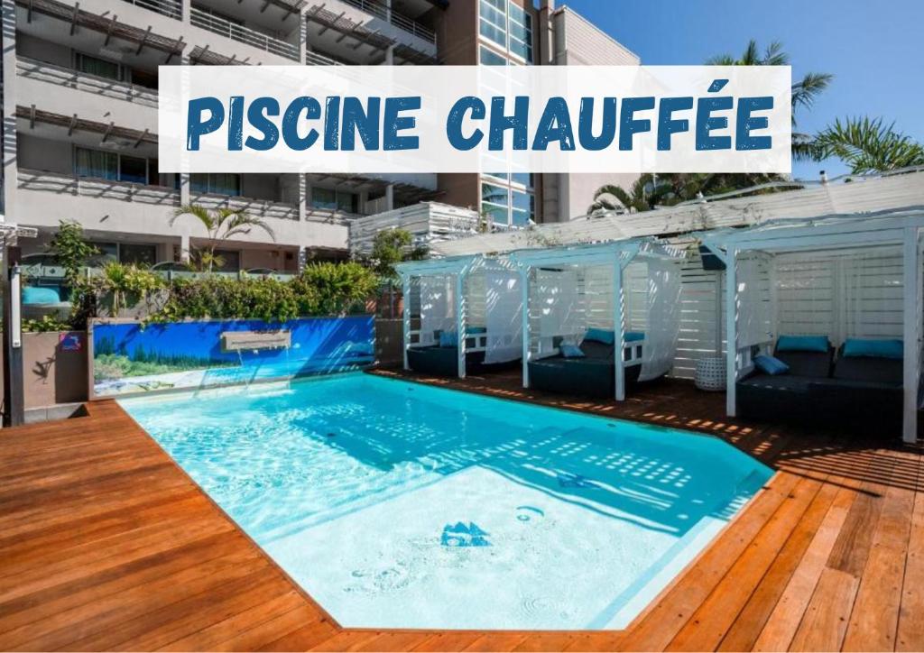 a swimming pool with a sign that reads prestige chidate at H&ocirc;tel Le Lagon in Noumea