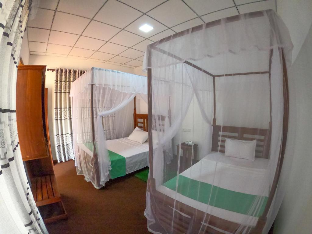 Postel nebo postele na pokoji v ubytování Wilpattu Mookalan Resort