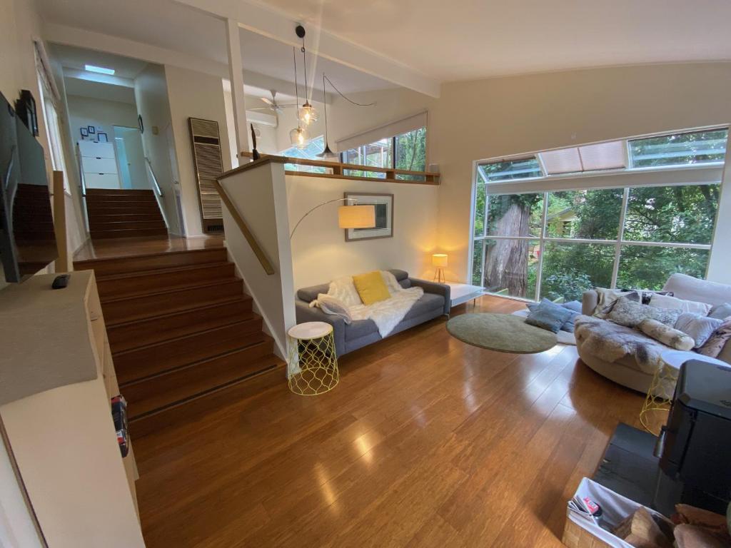 a living room with a couch and a table at Sassafras Treehouse Private home in the Dandenong Ranges, Victoria in Sassafras