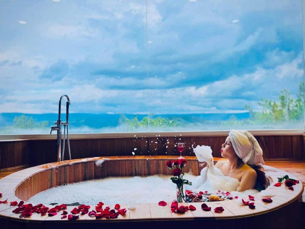 Xuan An的住宿－Khách Sạn Greenhills，坐在花卉浴缸中的女人