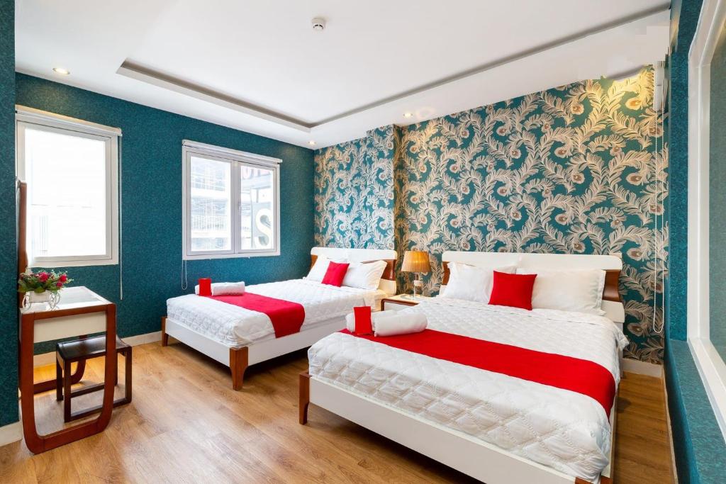 two beds in a room with blue walls at Spring Airport Hotel in Ho Chi Minh City