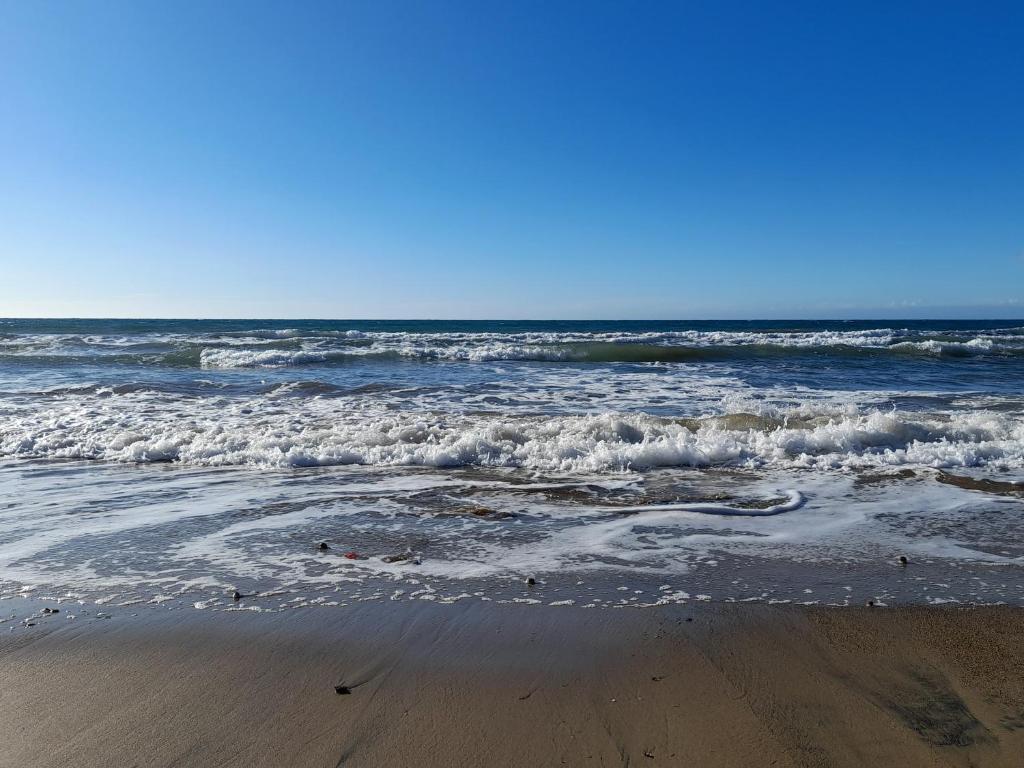 una playa con olas y el océano en un día soleado en Casa del Sole en Riotorto