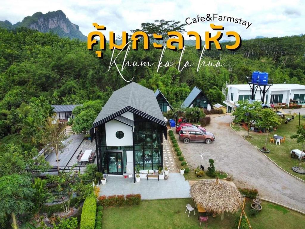 Ban Pha Saeng Lang的住宿－คุ้มกะลาหัวฟาร์มสเตย์ (Khumkalahua Farmstay)，前面有停车位的房子