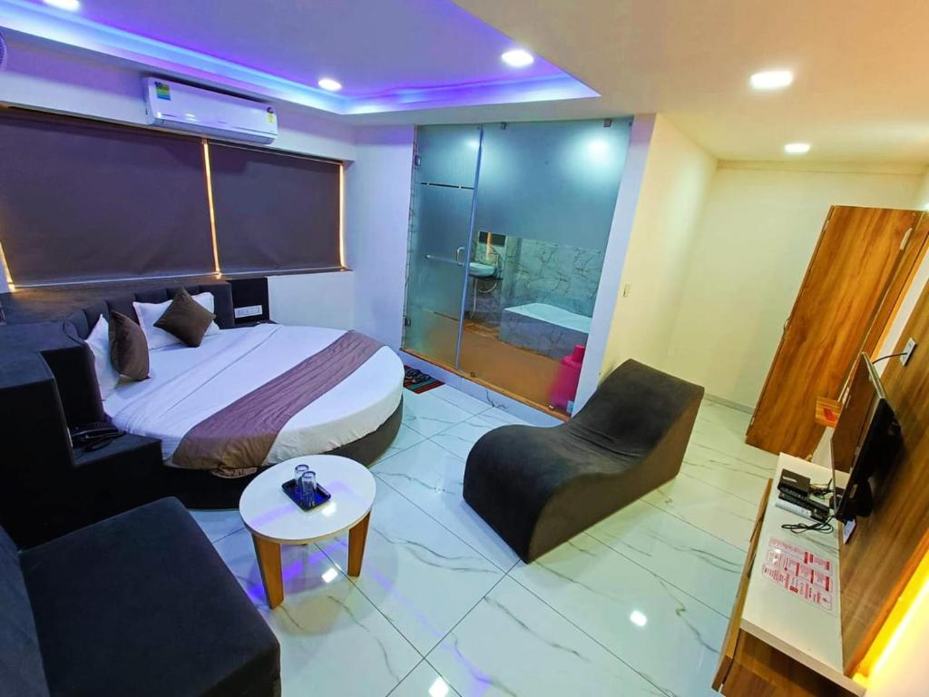 Habitación de hotel con cama y silla en HOTEL ROCK en Anand