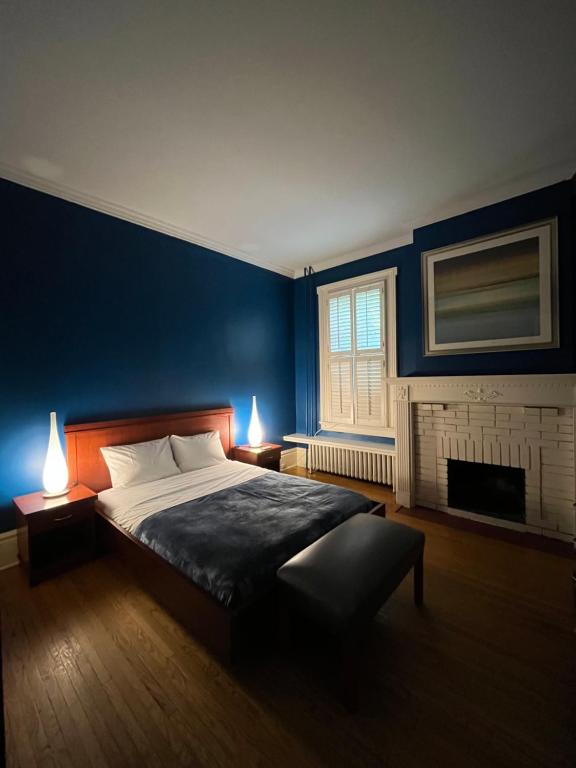 a blue bedroom with a bed and a fireplace at 49 Hostel in Toronto