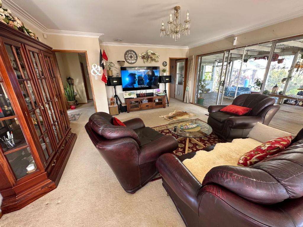 a living room with leather furniture and a television at Lucky house in Auckland