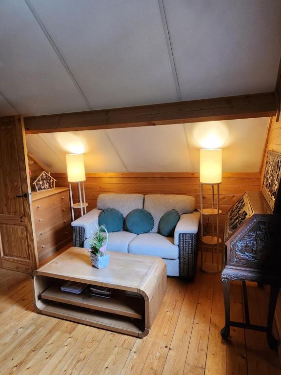 uma sala de estar com um sofá e uma mesa em Le chalet du Cerf - Chambres d'hôtes em Somme-Leuze