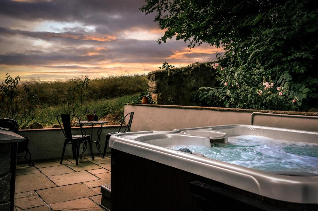 a jacuzzi tub sitting on a patio with a table at The Auld Reekie in Barbaraville