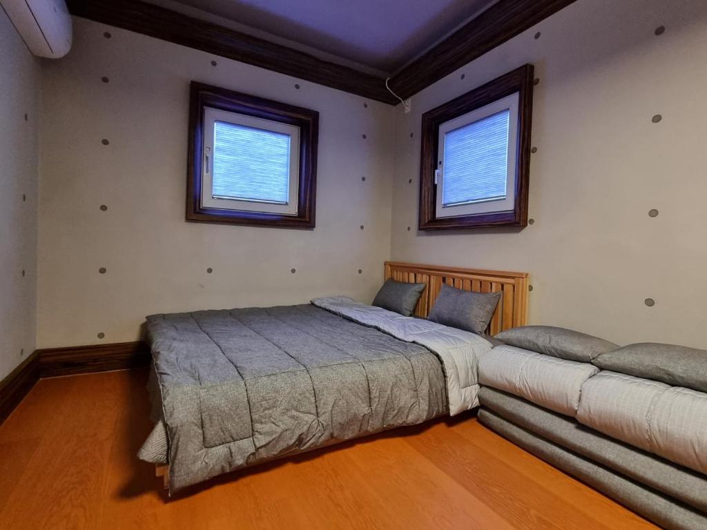 1 dormitorio con 1 cama grande y 1 sofá en Basecamp Pension, en Pohang