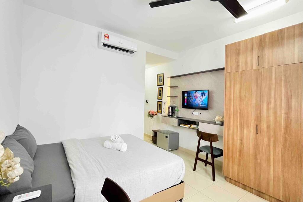 a bedroom with a bed and a desk and a tv at Studio Room Alanis Suite @ KLIA in Sepang