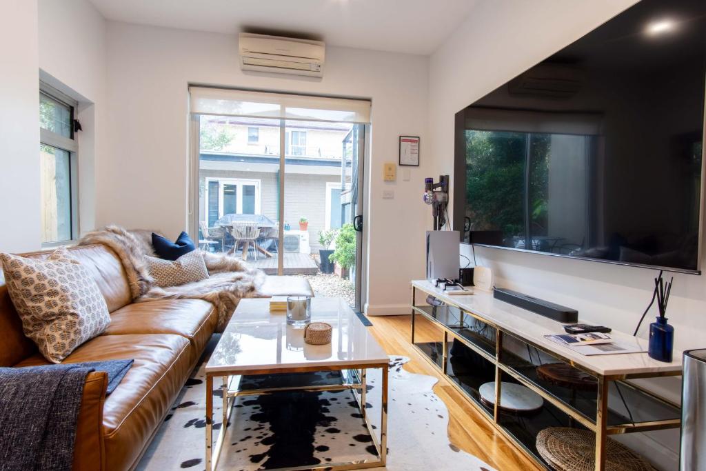 a living room with a couch and a tv at Eggies Nest - Sydney City Apartment in Sydney