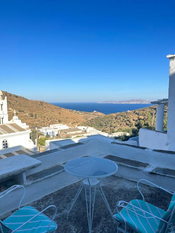 un tavolo e sedie sul tetto di una casa di Cycladic house with amazing view in Potamia village a Dhió Kkhoriá