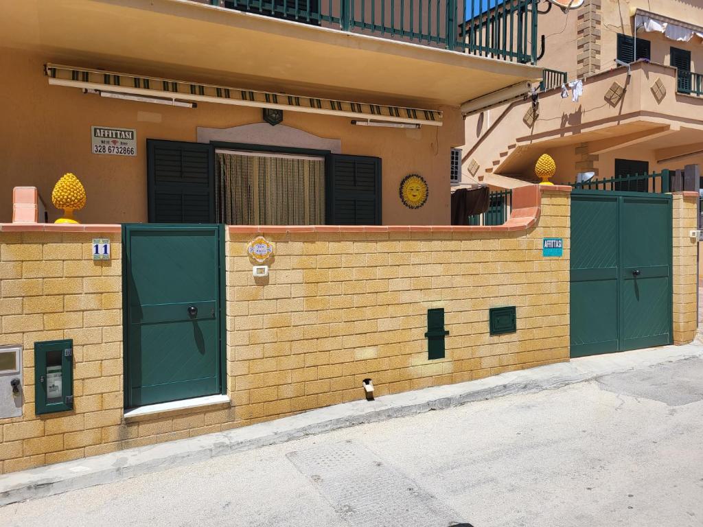 ein Gebäude mit grünen Türen an der Seite in der Unterkunft VILLETTA SCALA DEI TURCHI a SOLI 40 MT DAL MARE in Realmonte