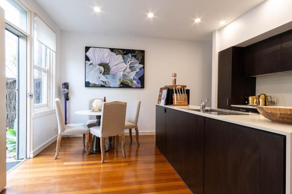 a kitchen with a counter and a table with chairs at Eggie's Nest - Luxury City Apartment in Sydney