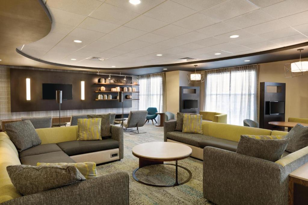 a living room with couches and chairs and a table at Courtyard by Marriott Fort Smith Downtown in Fort Smith