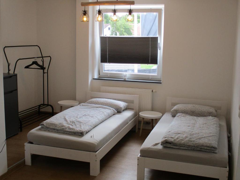 - une chambre avec 2 lits et une fenêtre dans l'établissement PARSBERGER FERIENWOHNUNG, à Parsberg
