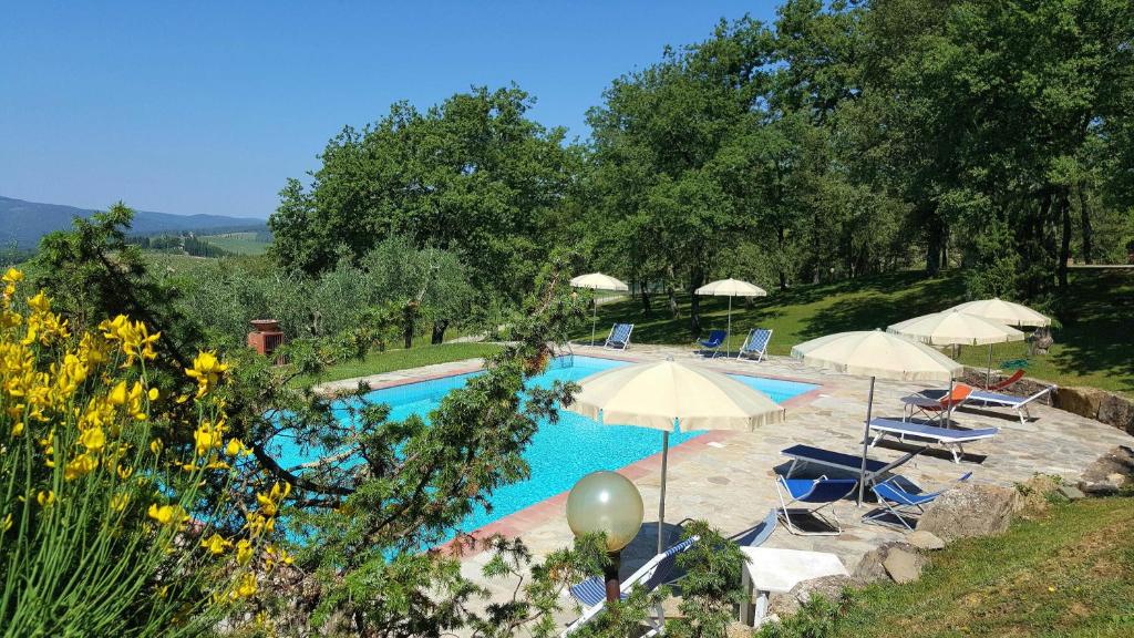una piscina con sombrillas y sillas en Holiday House Le Selvole, en Radda in Chianti