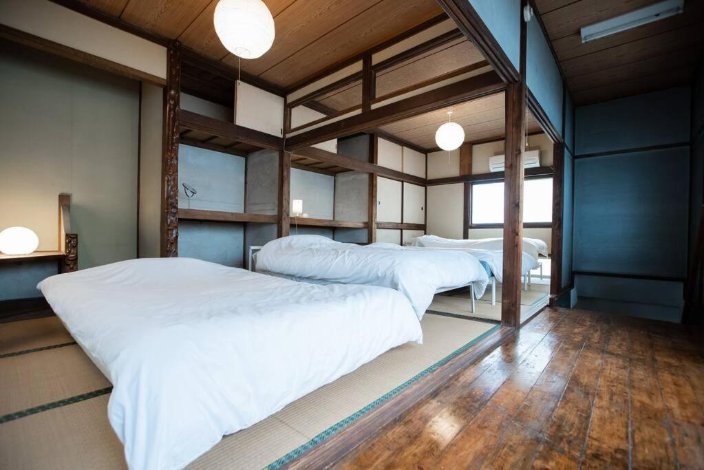 東京にある【70平米 長期予約大歓迎】6LDK/日本家屋貸切/大人数で寛げる空間の白いシーツとウッドフロアの客室で、ベッド2台が備わります。