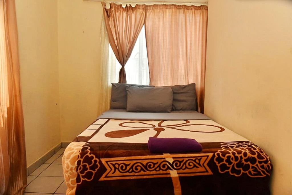 a bed in a room with a window at Asmara Hotel in Johannesburg