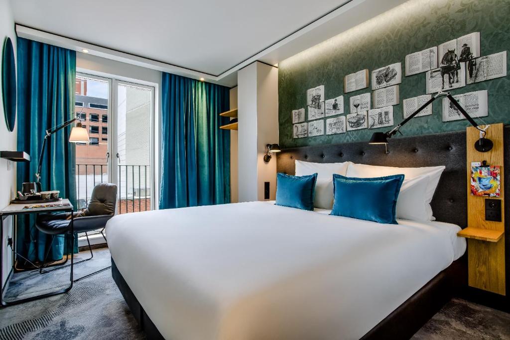 ein Hotelzimmer mit einem großen Bett und einem Schreibtisch in der Unterkunft Motel One Dublin in Dublin