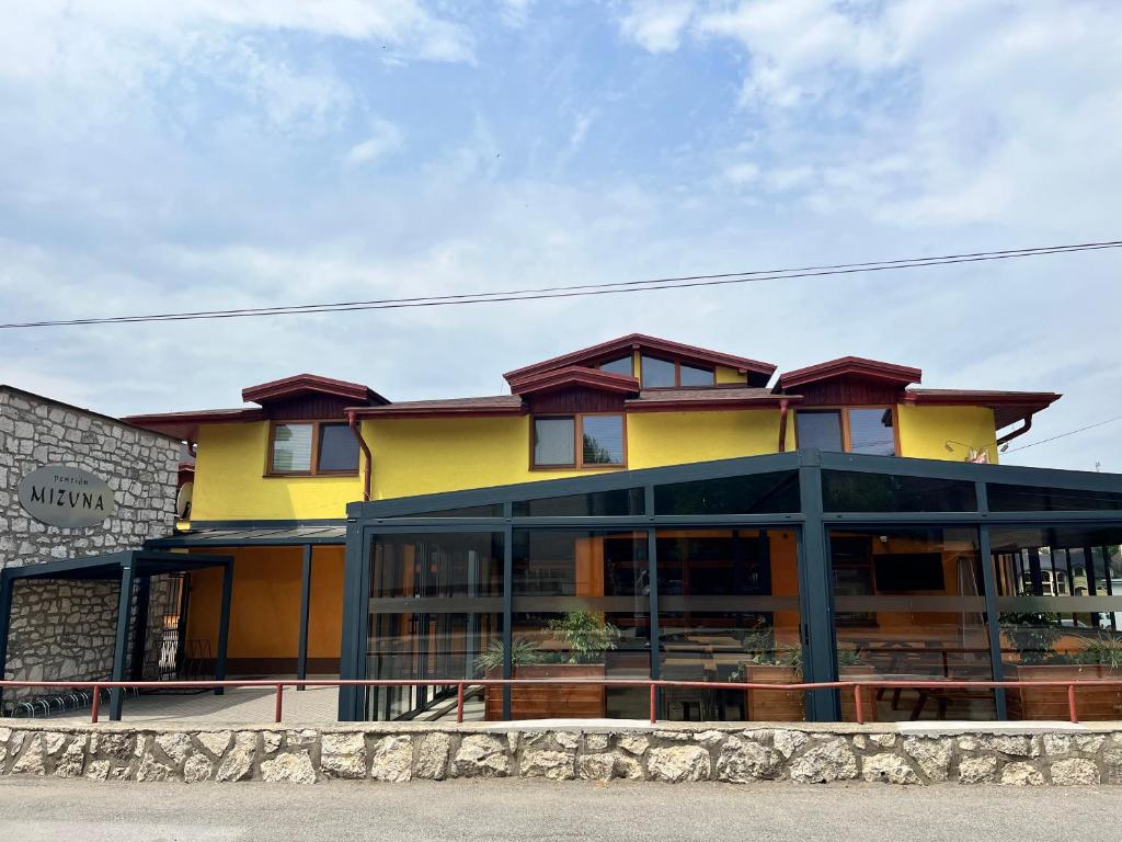 um edifício amarelo com muitas janelas em Penzión Mizuna em Hrabušice