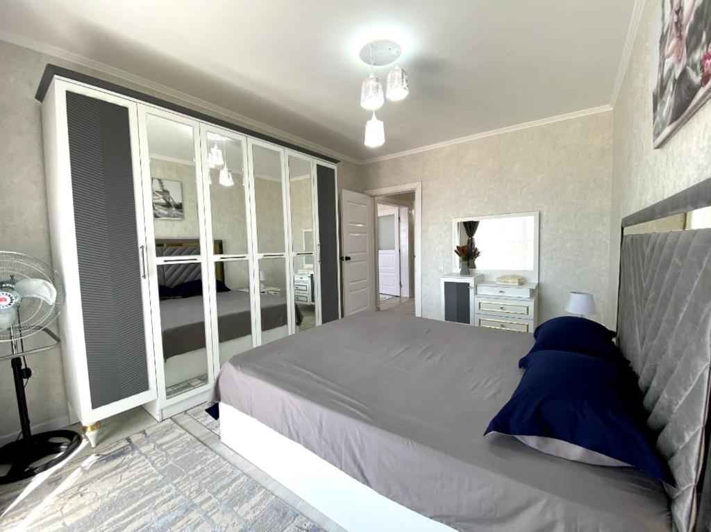 1 dormitorio con 1 cama grande con almohadas azules en Красивый вид города Туркестан, вид на озеро, караван сарай, en Türkistan